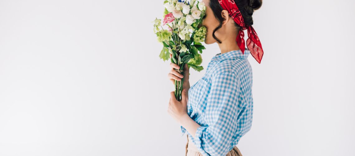 Side,View,Of,Woman,Covering,Face,With,Bouquet,Of,Flowers